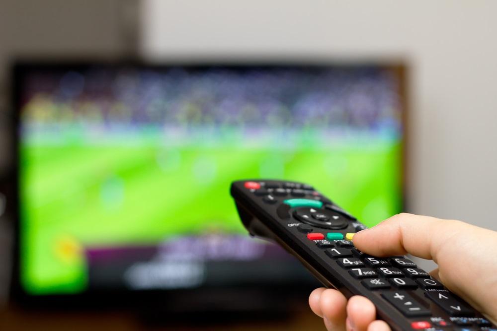 Billede af fjernbetjening og fodbold i TV